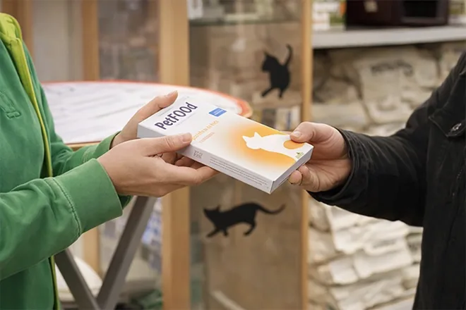 Übergabe einer Futterpackung an der Ausgabestelle
